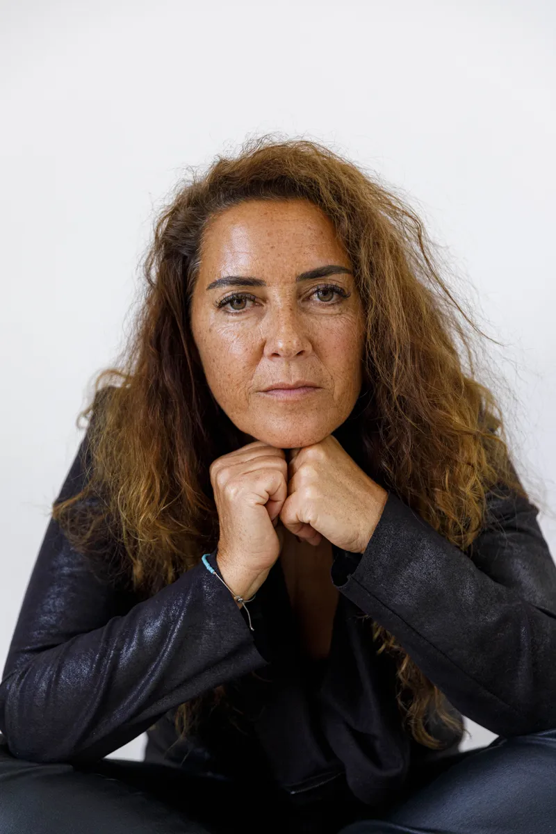 Portrait intense d'une comédienne aux cheveux bouclés le menton posé sur les poings