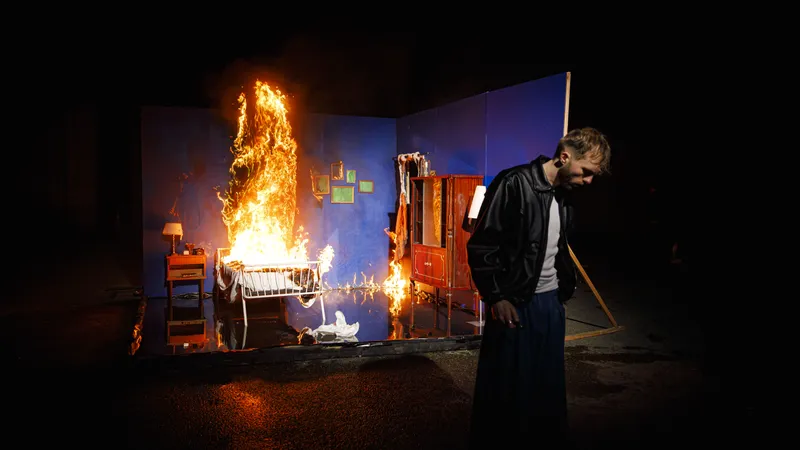 Comédien devant un décor en feu lors d'un tournage de clip musical