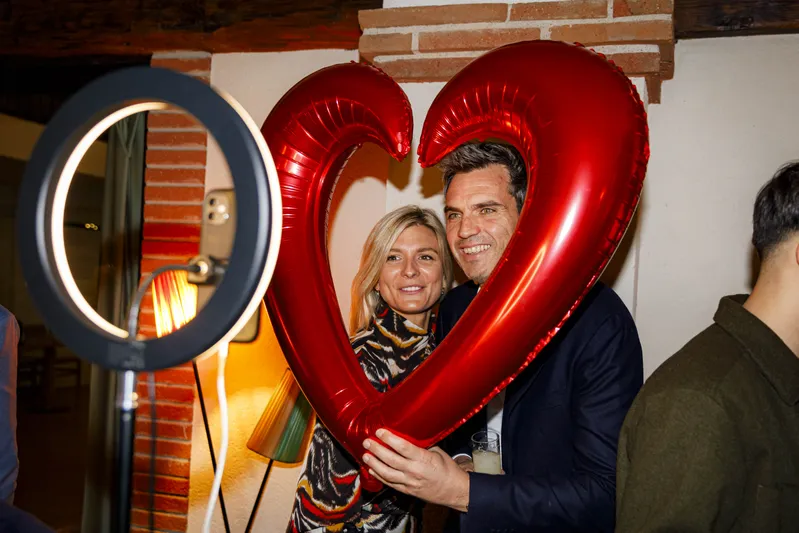 Couple posant avec un ballon coeur rouge lors d'un photobooth