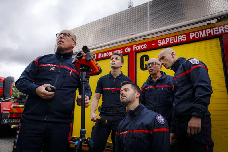 Équipe de pompiers devant un véhicule de manoeuvres de force