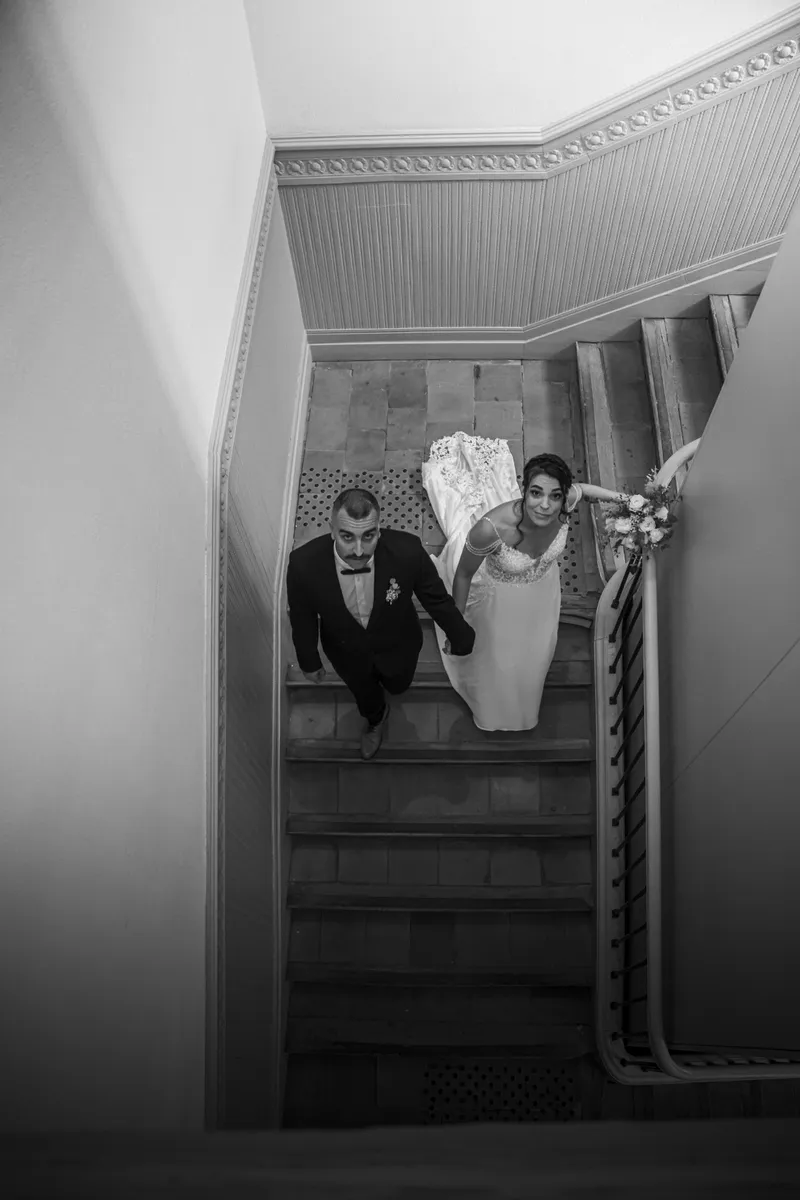 Couple de mariés descendant un escalier en noir et blanc