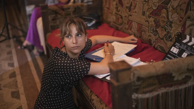 Scripte prenant des notes sur un plateau de tournage décoré