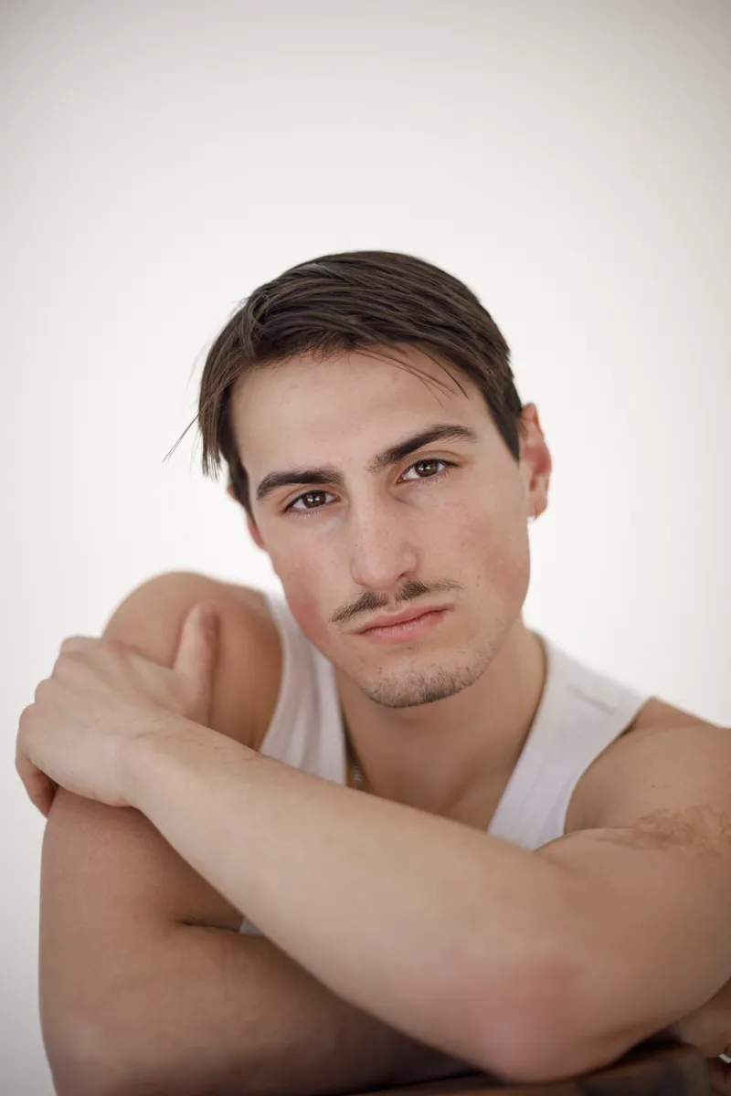 Portrait d'un comédien au regard doux en débardeur blanc