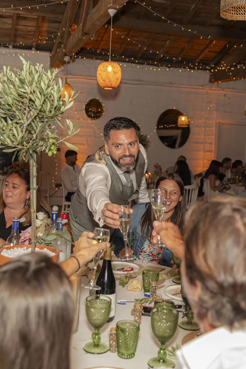 Marié trinquant joyeusement avec ses invités lors du repas de mariage