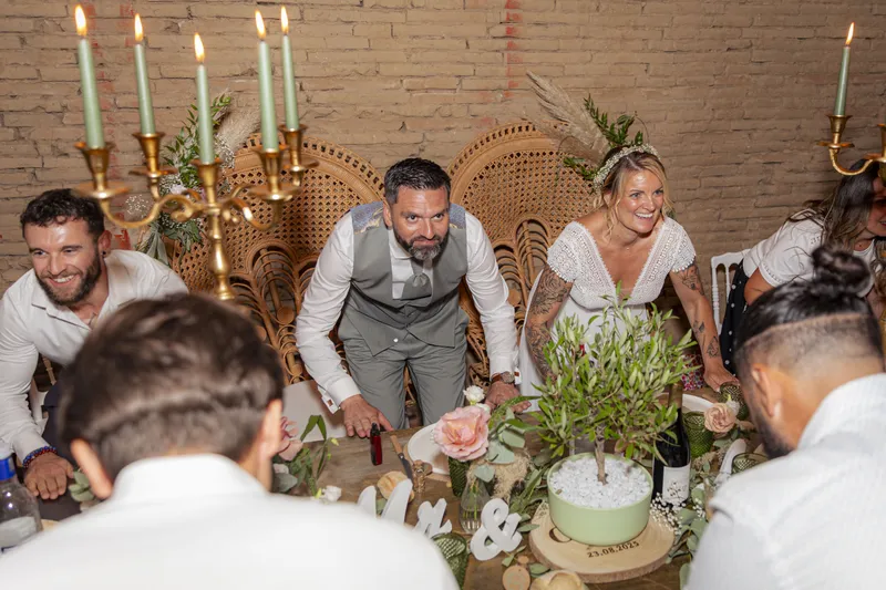Couple de mariés coupant le gâteau de mariage décoré de feuillage