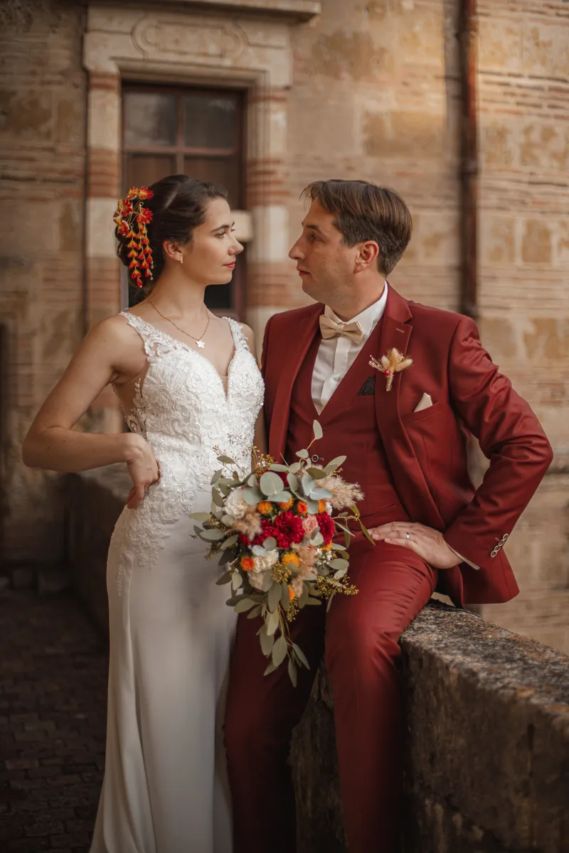 Portrait rapproché des mariés se regardant avec tendresse devant un château