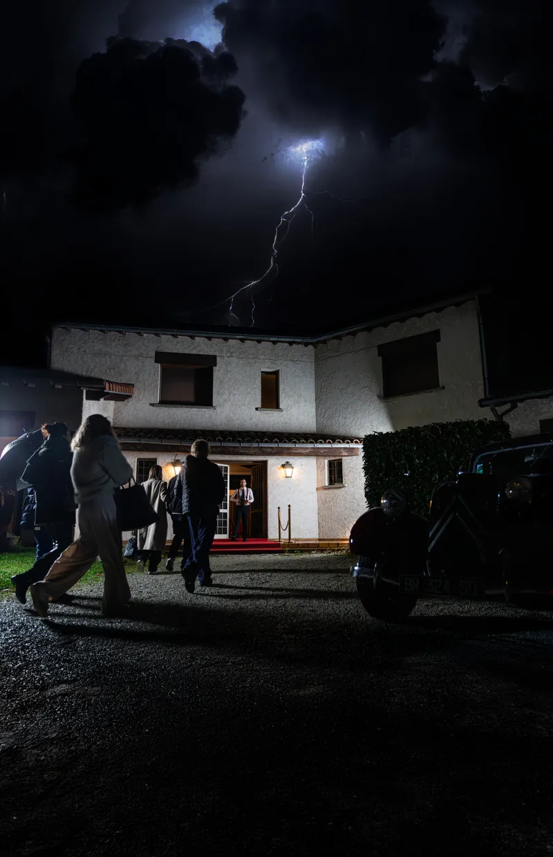 Invités arrivant à une soirée sous un éclair dans le ciel nocturne