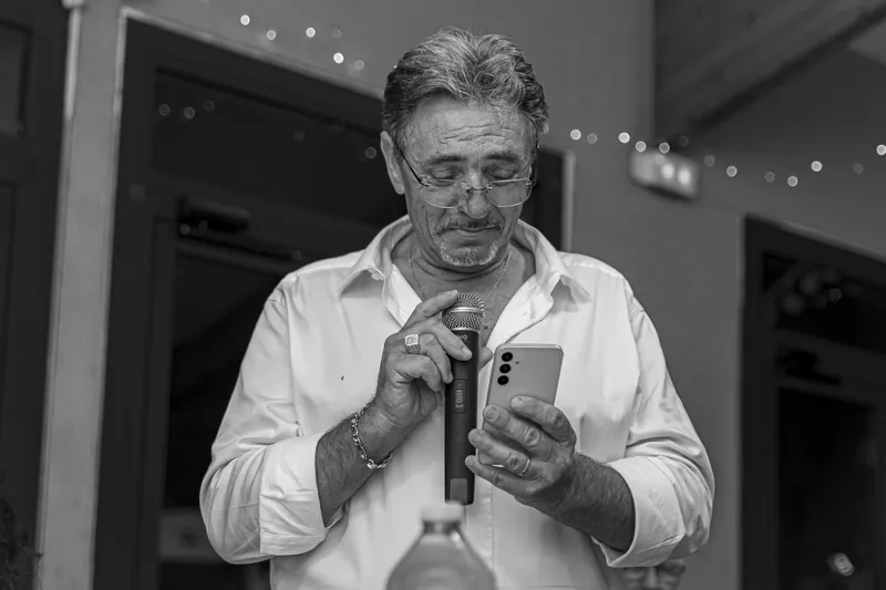 Invité lisant un discours au micro lors d'une réception, noir et blanc