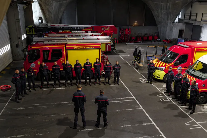 Pompiers en formation au garde-à-vous dans le garage de la caserne
