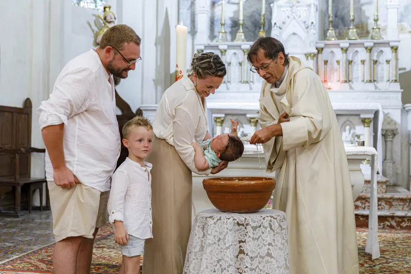 Baptême d'un nouveau-né aux fonts baptismaux dans une église