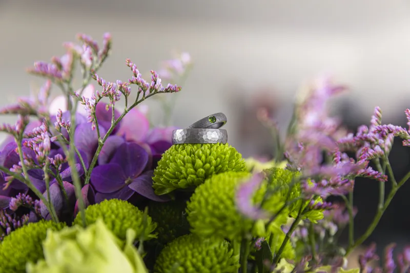 Alliances de mariage posées sur un bouquet de fleurs violettes et vertes