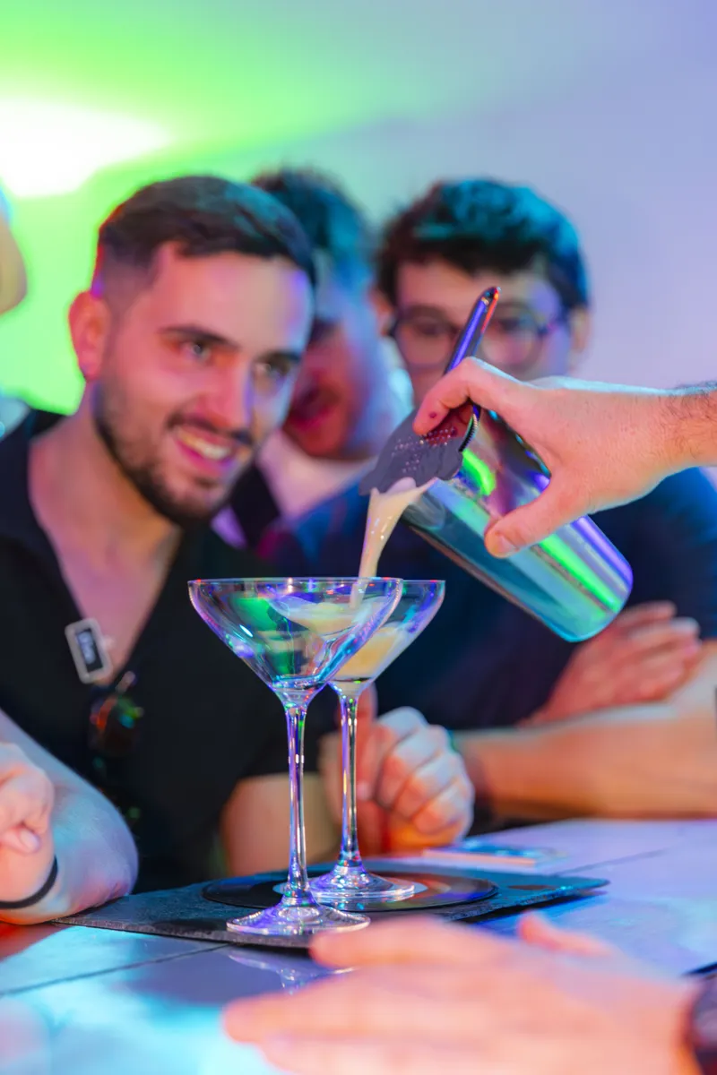 Barman préparant des cocktails dans des verres à martini lors d'une soirée