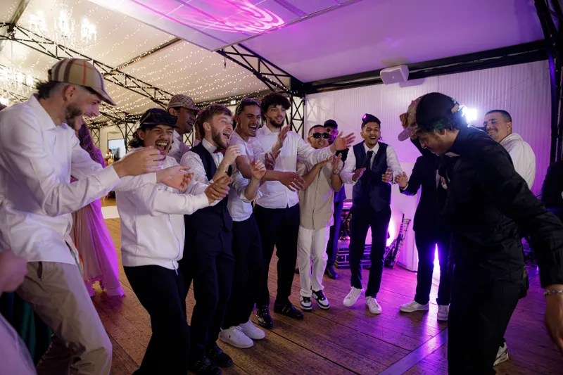 Groupe d'amis du marié dansant et chantant lors de la soirée de mariage