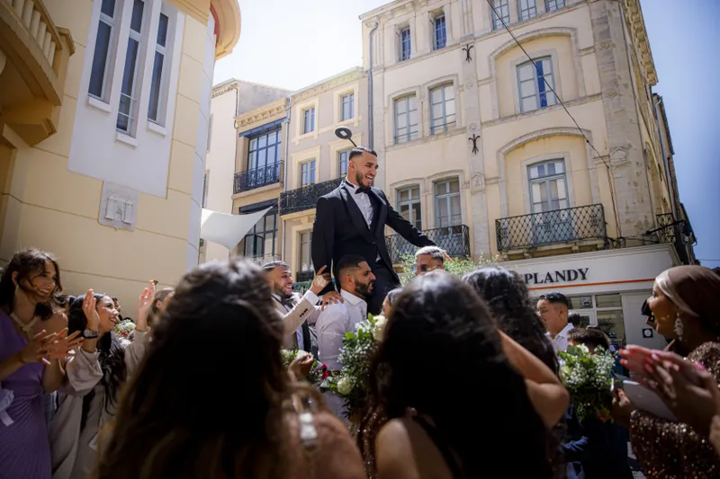 Marié soulevé sur les épaules par les invités lors d'une célébration en ville