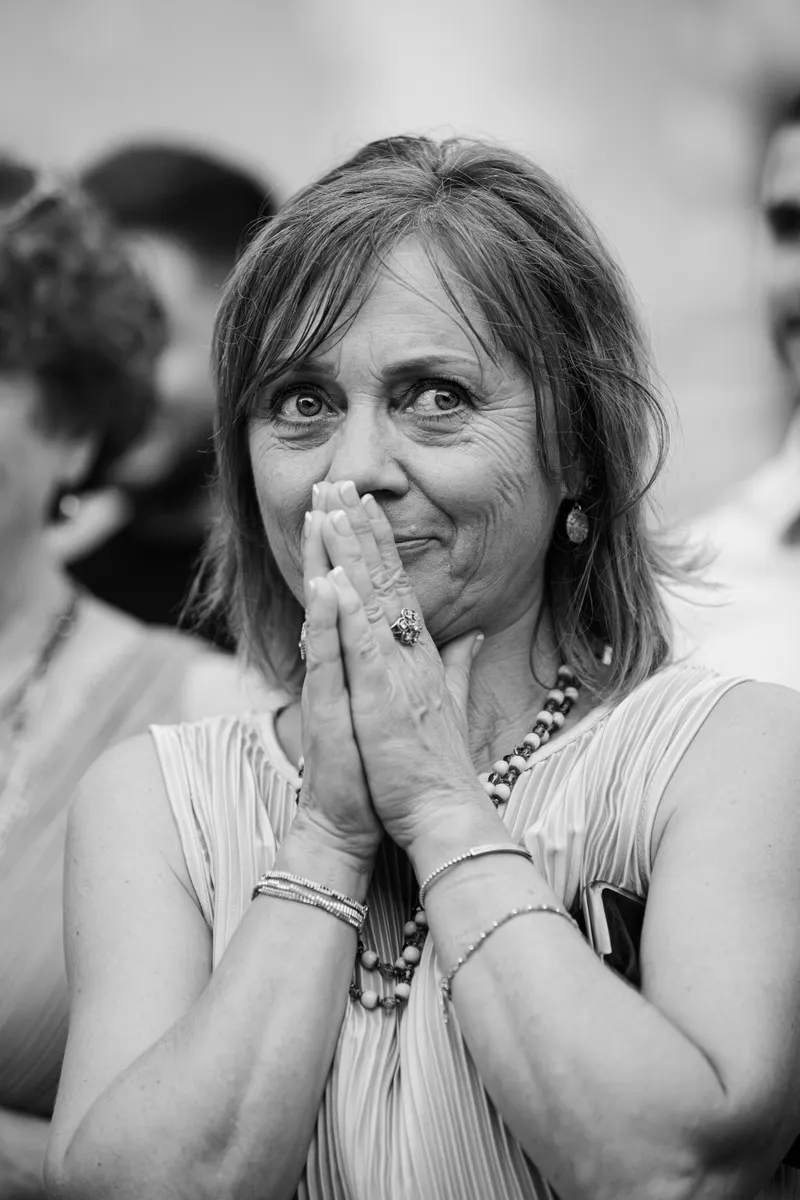 Invitée émue les mains jointes lors d'une cérémonie de mariage, noir et blanc