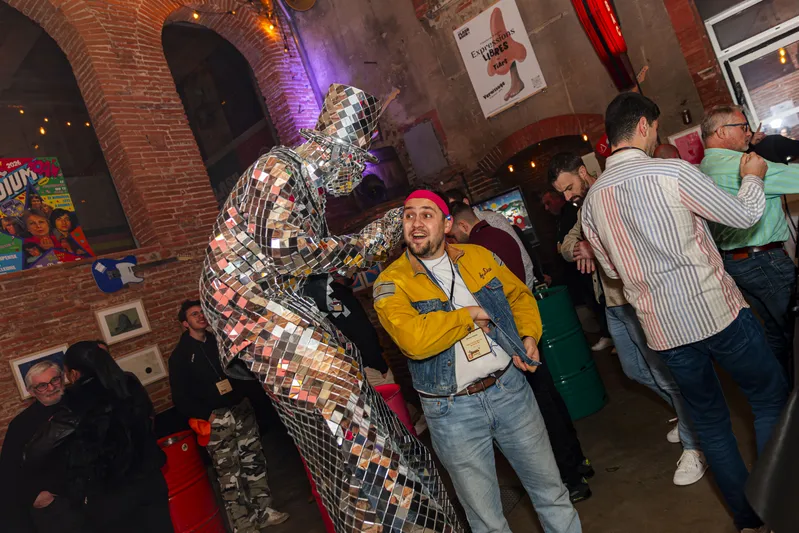 Invité posant avec un personnage en costume miroir lors d'une soirée