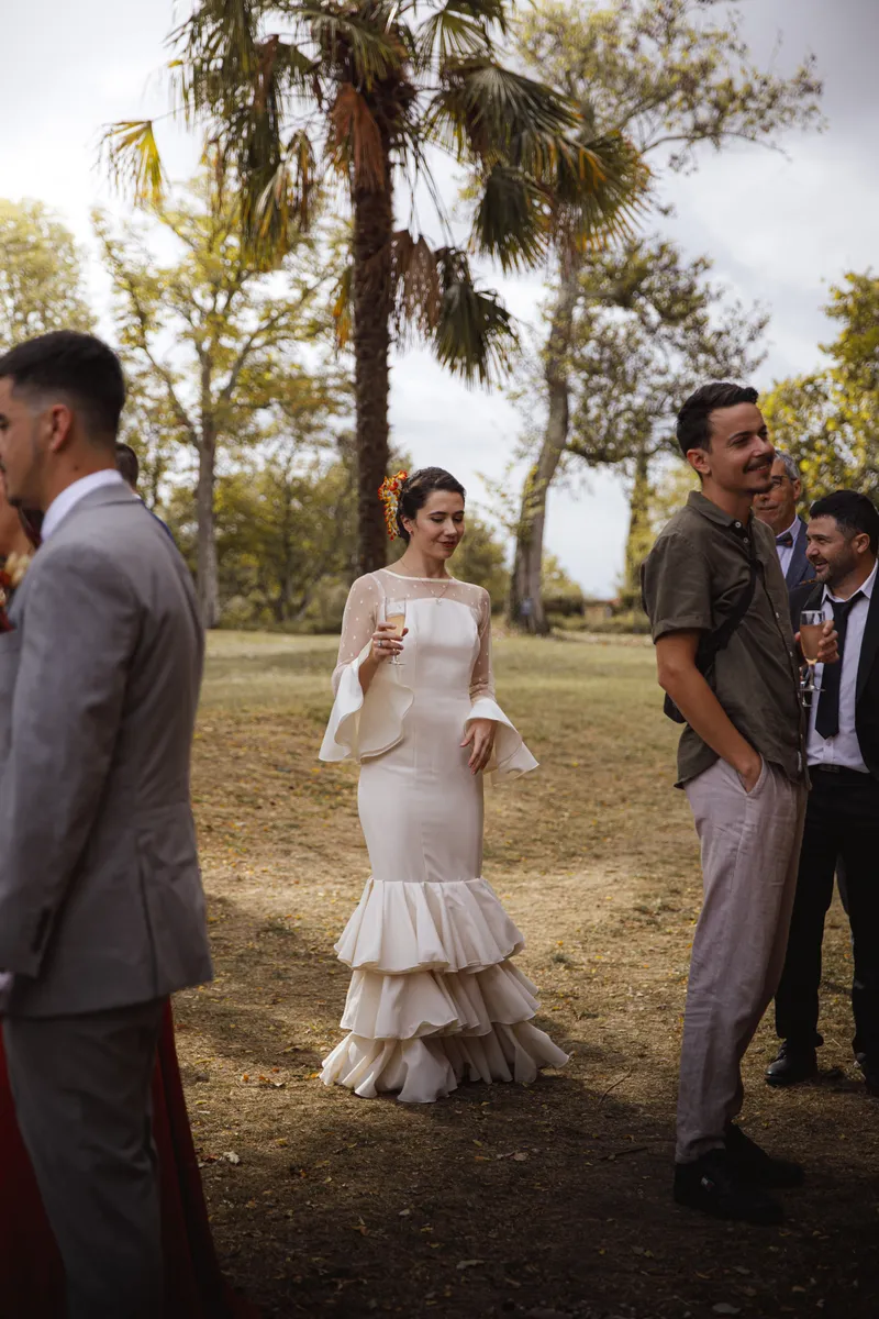 Mariée en robe à volants discutant avec des invités lors du vin d'honneur