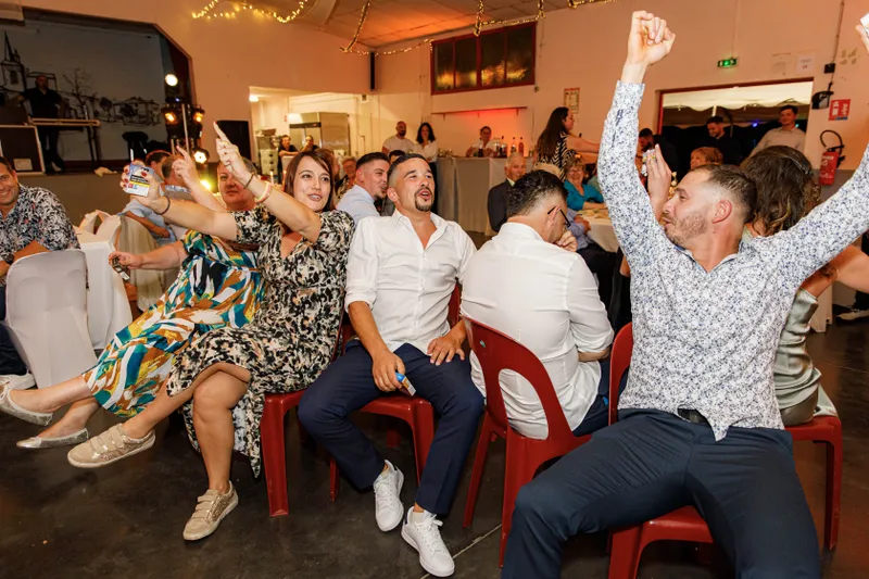 Invités enthousiastes levant les bras lors d'une soirée de mariage