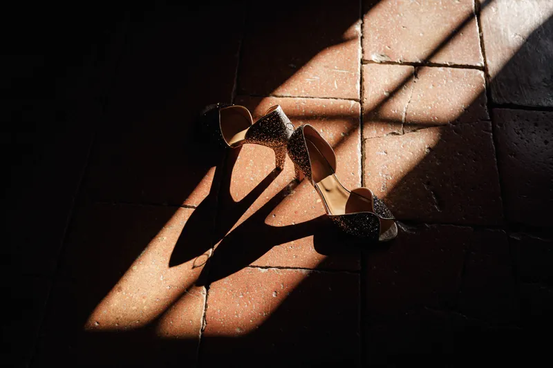 Chaussures à talons de la mariée posées au sol dans un rayon de lumière