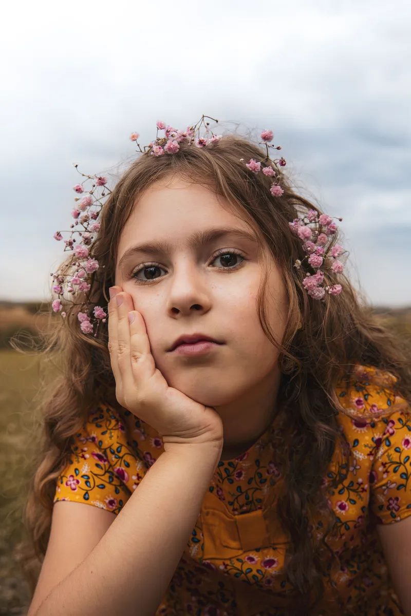 Portrait d'une petite fille avec une couronne de fleurs dans un champ