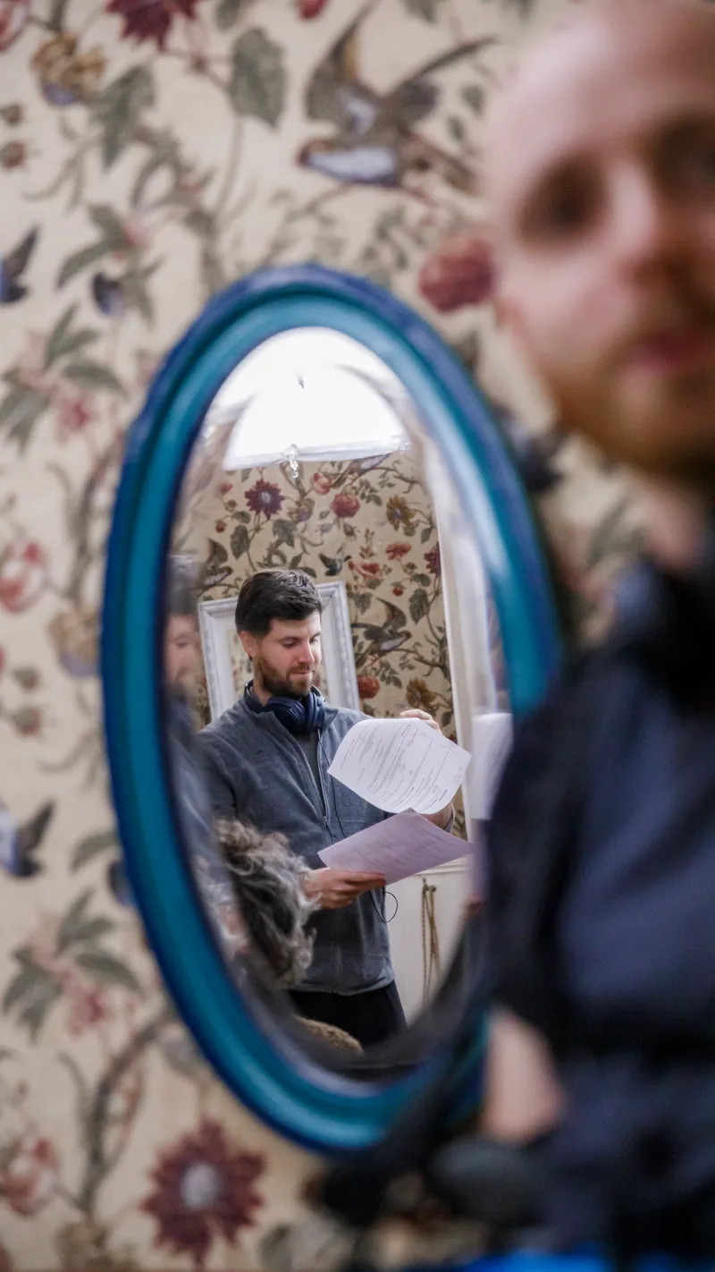 Comédien lisant un script devant un miroir sur un plateau de tournage