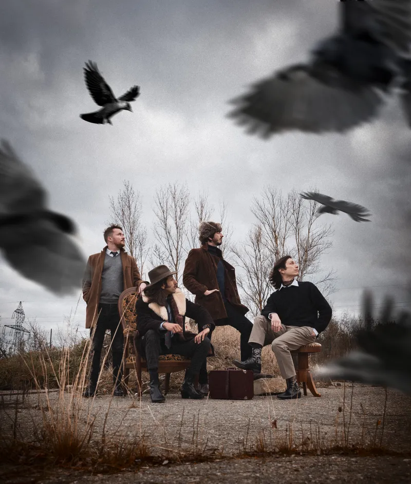 Portrait artistique d'un groupe de musiciens posant en extérieur avec des corbeaux