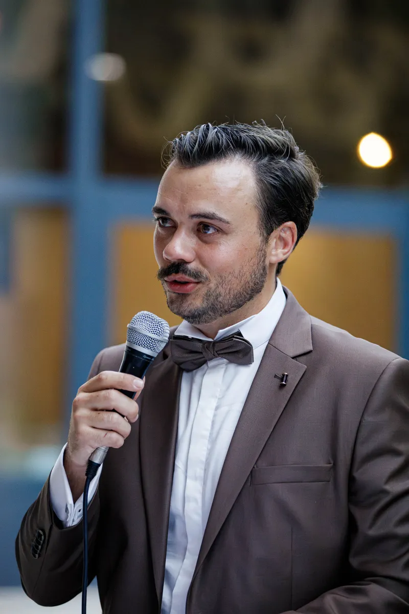 Témoin prononçant un discours au micro lors d'une réception de mariage