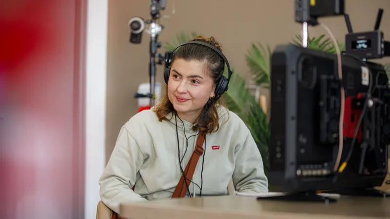 Technicienne son portant un casque audio et souriant sur un plateau