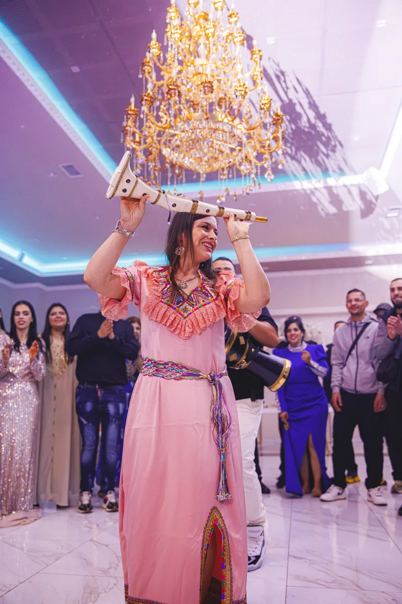 Invitée dansant en robe traditionnelle rose lors d'une soirée de mariage