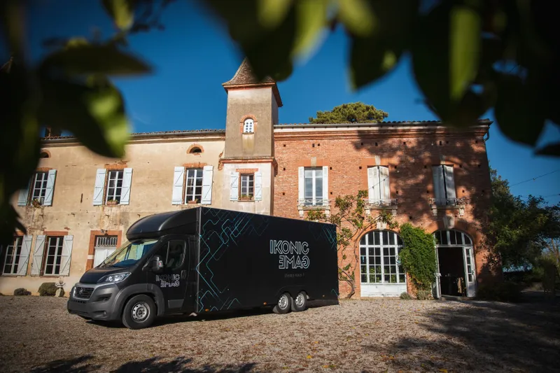 Camion événementiel Ikonik Game stationné devant un château toulousain