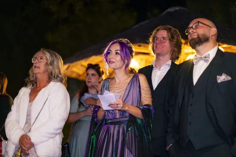 Mariée en robe violette avec ses proches lors d'une soirée de mariage en extérieur