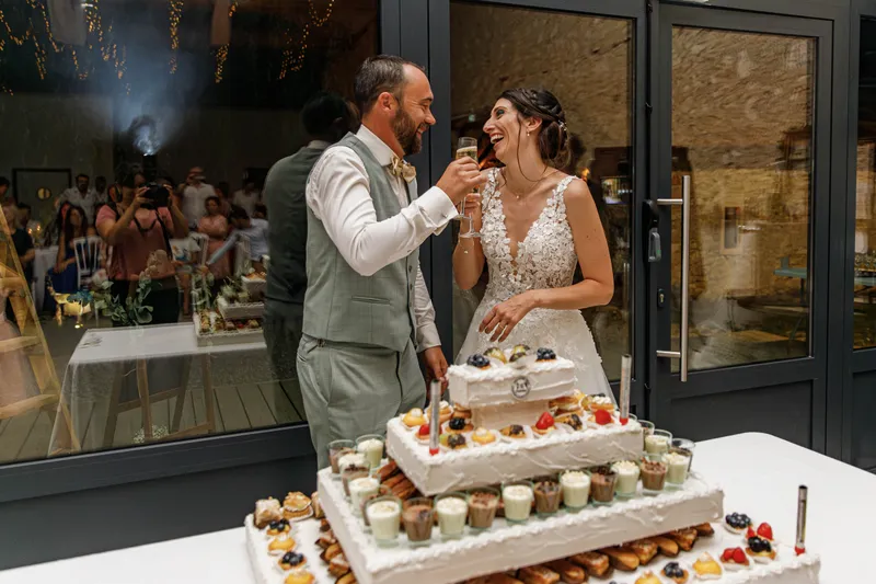 Mariés trinquant devant leur pièce montée lors de la soirée de mariage
