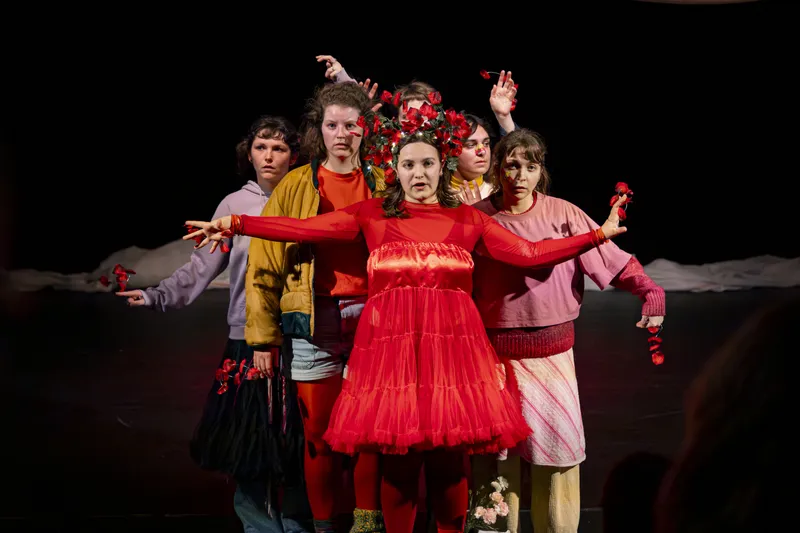 Jeunes comédiennes en costumes rouges et colorés lors d'une représentation théâtrale