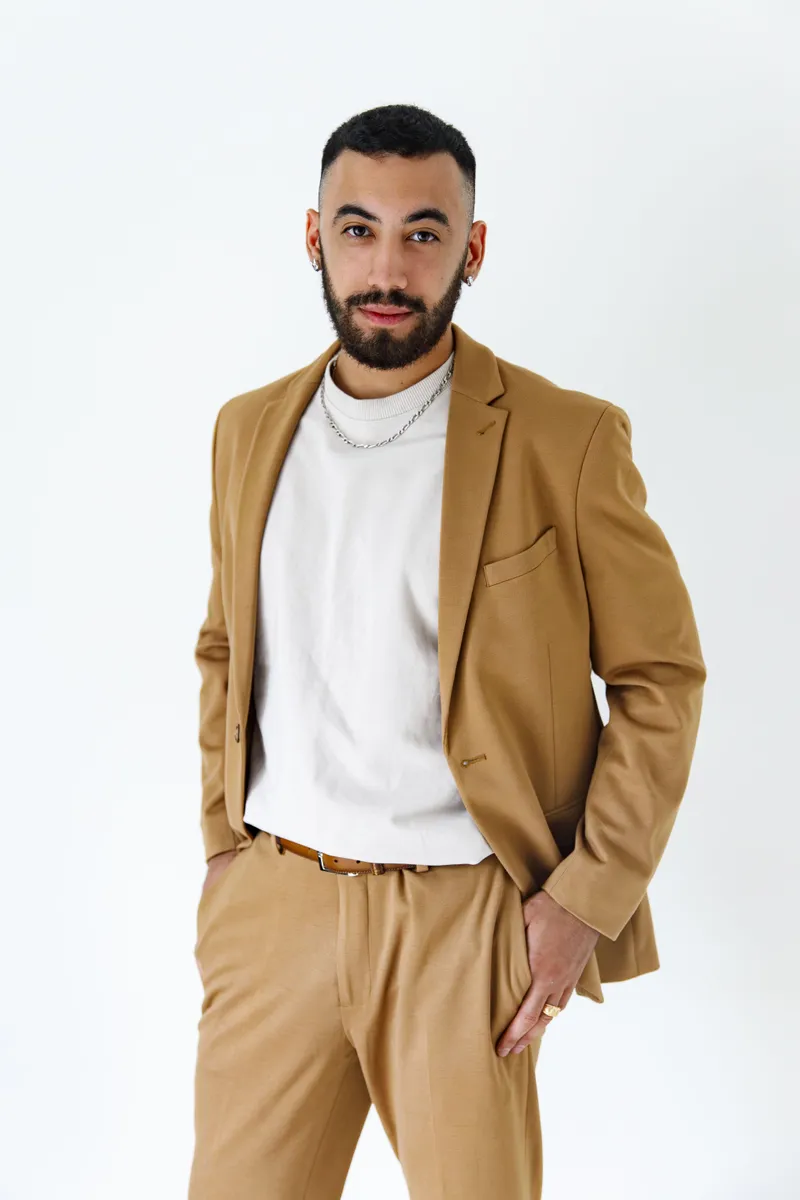 Portrait d'un comédien en costume camel et t-shirt blanc