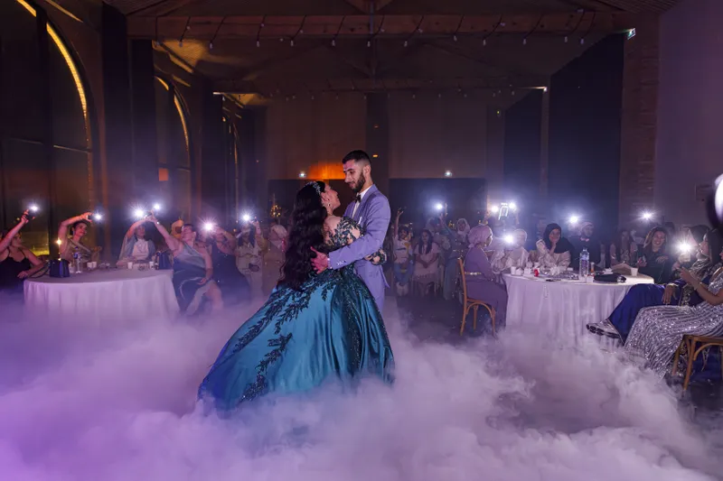 Première danse du couple dans une salle décorée avec fumée et éclairage