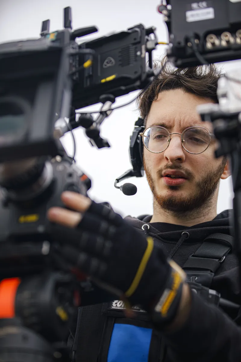 Cadreur ajustant sa caméra cinéma en gros plan