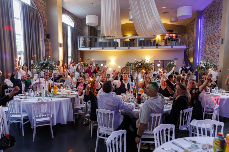 Salle de réception de mariage avec les invités levant leurs verres pour trinquer