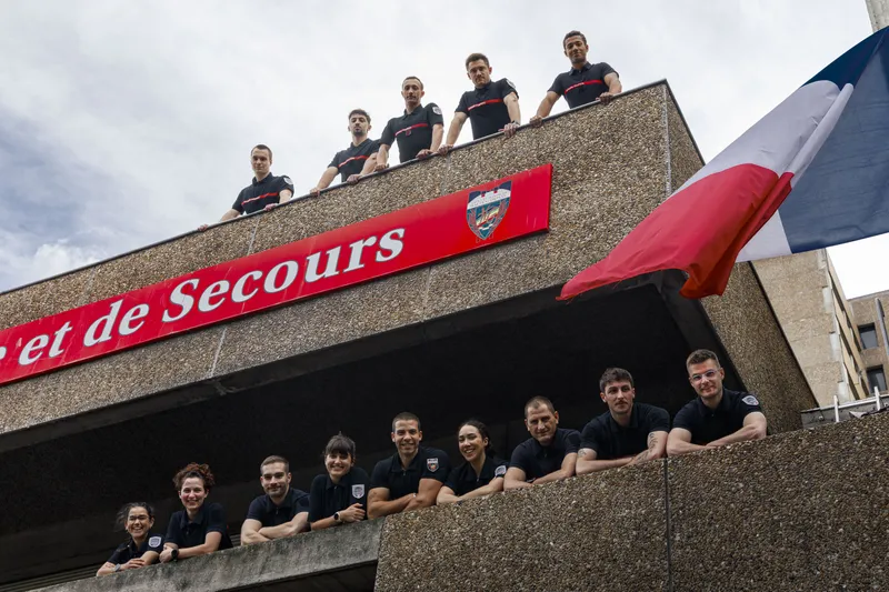 Équipe de pompiers posant sur le balcon de leur centre de secours