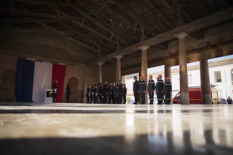 Cérémonie de la Sainte-Barbe avec pompiers au garde-à-vous devant le drapeau français