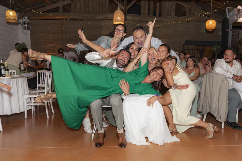 Groupe d'invités posant joyeusement avec le marié lors de la soirée